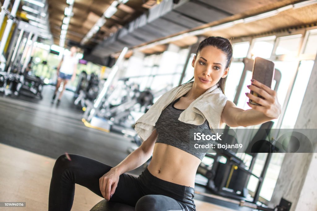 Young sportswoman taking selfie after sports training in gym Selfie Stock Photo