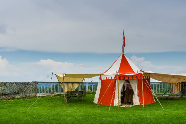istock Red and white traditional tent on green meadow 1014940410