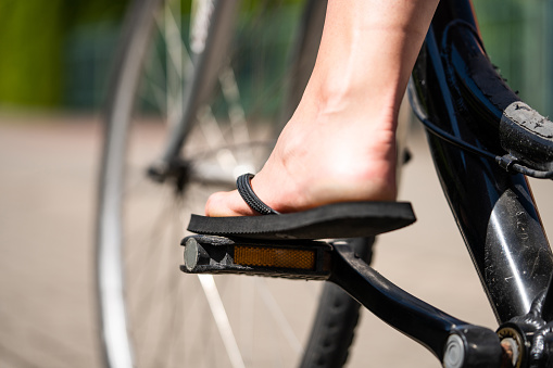 A girl is riding her bike with flip flops.