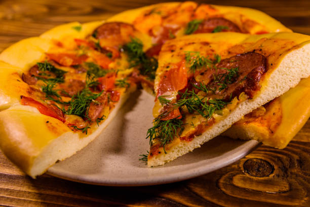 istock Ceramic plate with sliced homemade pizza on a wooden table 1014943612