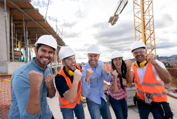 istock Group of architecs looking very happy at a building site 1014950868