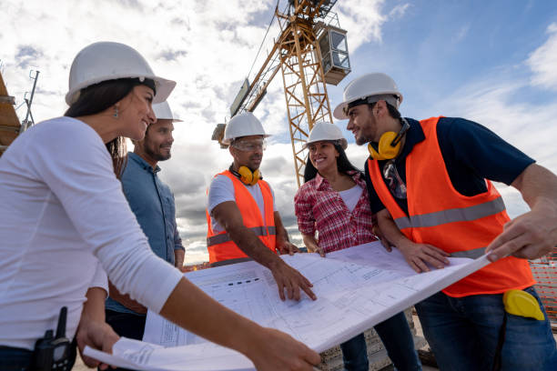 istock Group of civil engineers looking at a blueprint at a construction site 1014950906