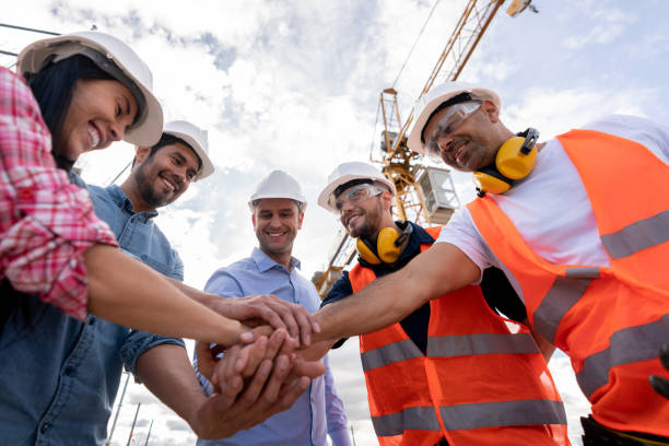 istock Team of architects with hands together at a construction site 1014950986