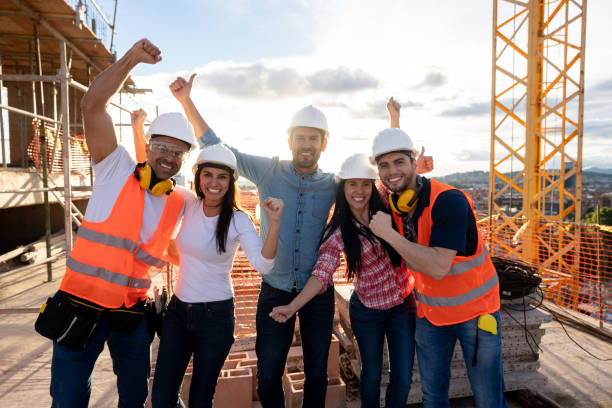 istock Group of construction workers looking very happy at a building site 1014951170