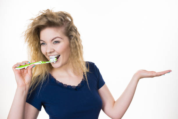 istock Woman brushing teeth holds open hand 1014954082