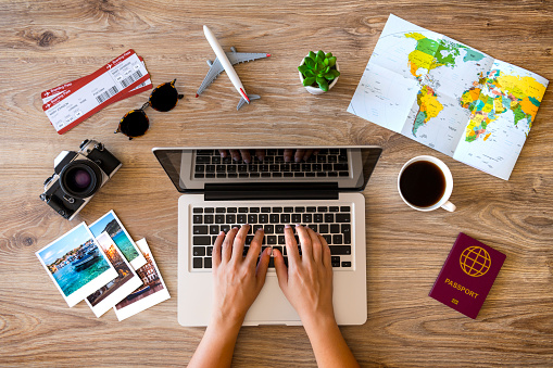 Woman using laptop and making a reservation for her travel.