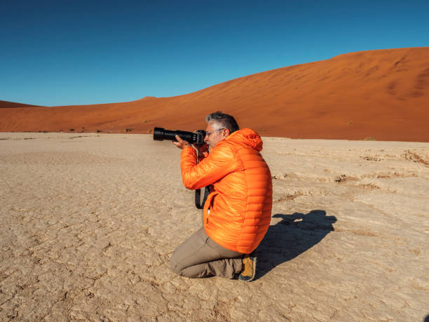istock Man taking pictures on dry desert 1014979528