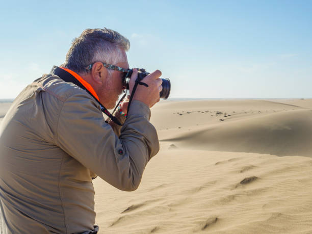 Man taking pictures on desert Photographer taking some pictures of the dunes over the sand on Namib desert, Namibia tecnología inalámbrica stock pictures, royalty-free photos & images