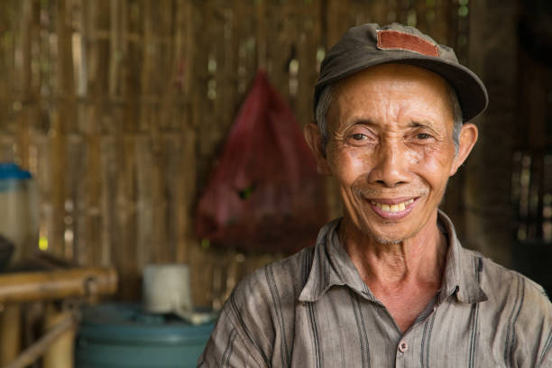 senior indonesische bauer lächelnd porträt in hütte - indonesien stock-fotos und bilder