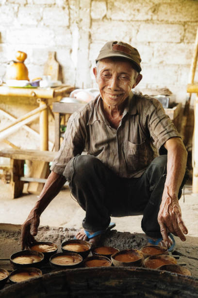 istock Senior artisan Indonesian palm sugar maker smiling in his kitchen 1014987276