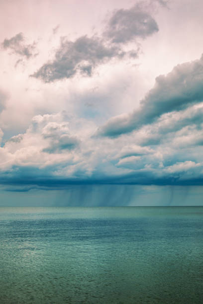 A rain cloud dropping rain in the distance on the waters of Lake Erie in Presque Isle, Erie, Pennsylvania.