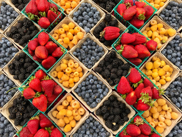 variety of fresh berries displayed in the market - market fruit strawberry farmers market imagens e fotografias de stock