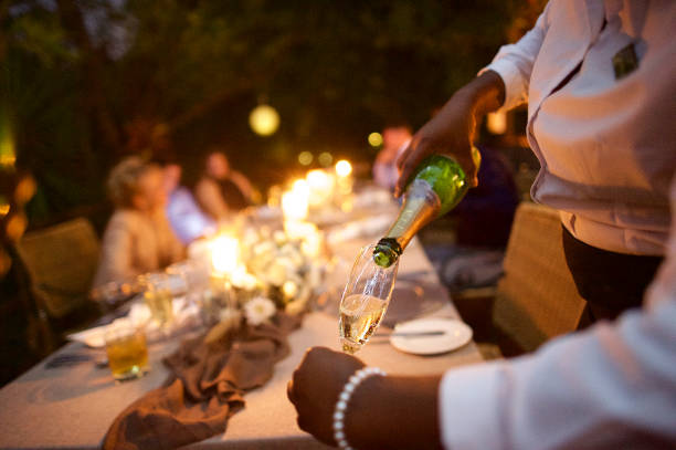versamento di champagne alla celebrazione del matrimonio all'aperto della cameriera africana - champagne wedding luxury dinner foto e immagini stock