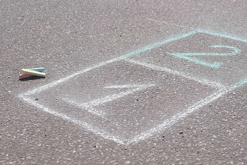 Hopscotch on the asphalt with chalks outdoor