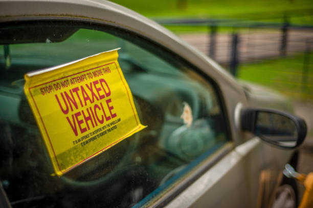 Untaxed And Clamped Car Detail Of A Warning Sign On The Window Of An Untaxed Vehicle WIth A Clamp On The Front Wheel car boot stock pictures, royalty-free photos & images