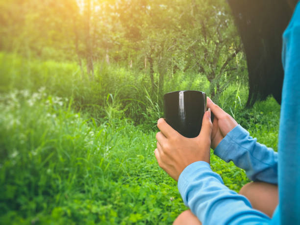 istock Young woman relaxes and drinks coffee in nature. 1015037552