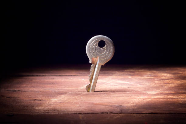 istock old key standing upright on a wooden table surface 1015042382