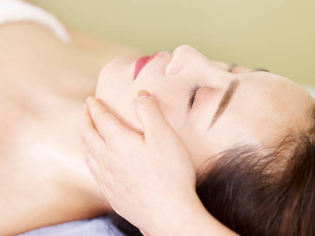 istock young asian woman enjoying a face massage 1015045252