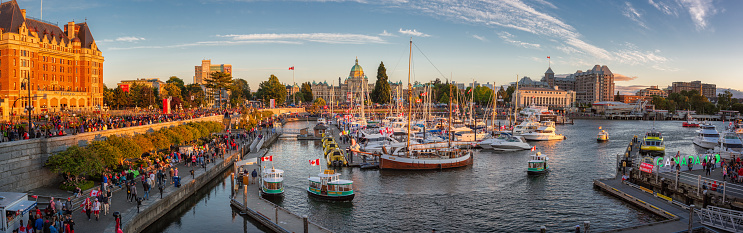 Día de Canadá en Victoria, isla de Vancouver, Canadá. Masas de personas que visitan las celebraciones en el puerto interior con el Parlamento durante la puesta de sol. photo