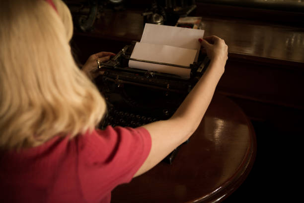 istock The girl is writing on a typewriter in the past. 1015055124