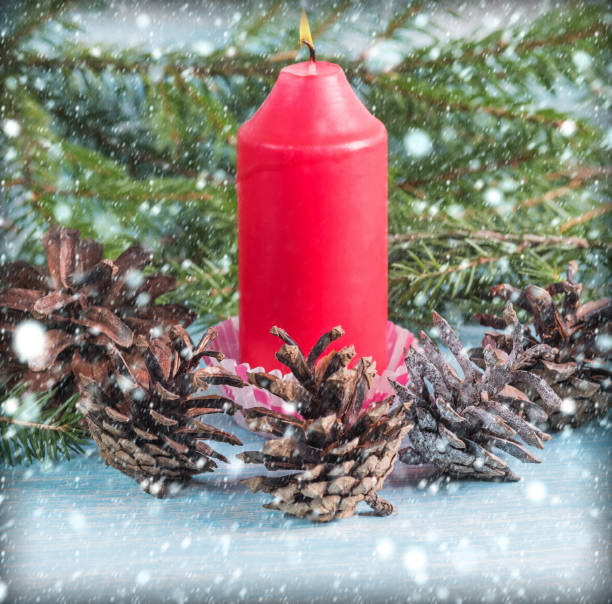istock Burning red candle with cones around. On a wooden background 1015089812