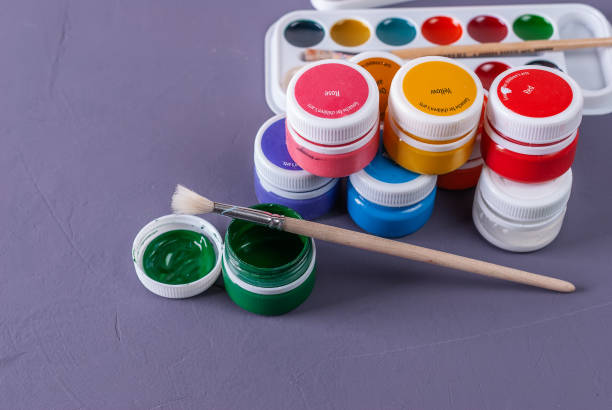 istock Opened gouache paint buckets with brush. 1015090100