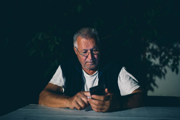istock Senior man uses his mobile phone for text messaging at night 1015099492