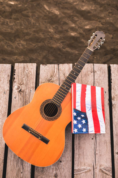 istock Guitar and book sitting by the lake 1015114492
