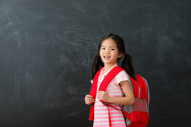 istock confident young little girl student carrying bag 1015117248