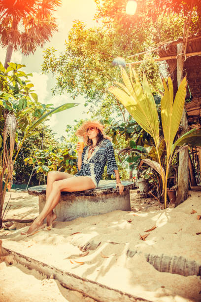 Woman drinks fresh juice on the beach