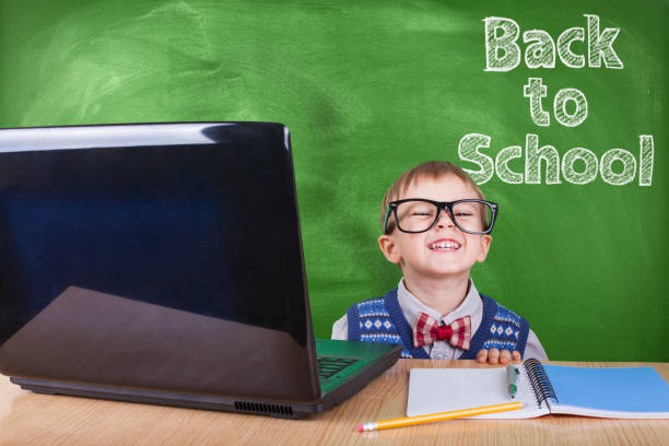 istock Child with laptop peeking in the classroom 1015137366