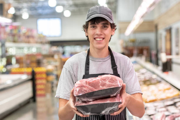 young man working at a supermarket - supermarket meat store manager imagens e fotografias de stock