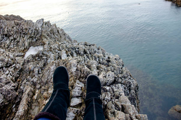 istock Feet hang on the edge of a cliff. 1015168830