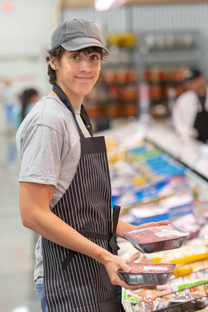 young man working at a supermarket - supermarket meat store manager imagens e fotografias de stock