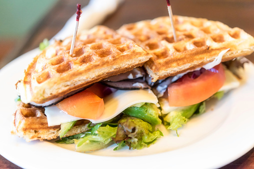 Avocado, vegetables, toast beef and cheese Belgian waffle sandwich