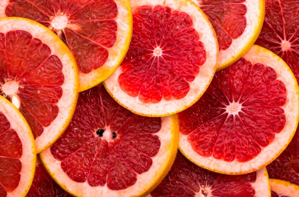 istock Sliced grapefruits, background, natural texture of citrus, top view, close-up 1015212486