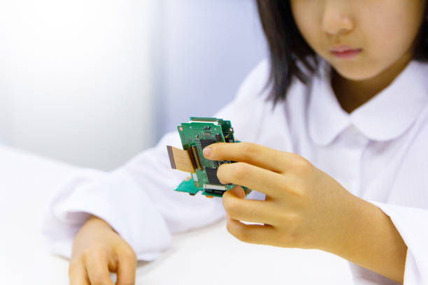 Asian girl assembling circuit board, close-up Japanese schoolgirl assembling circuit board, close-up apple iphone 8 plus screen repairs in griffin stock pictures, royalty-free photos & images