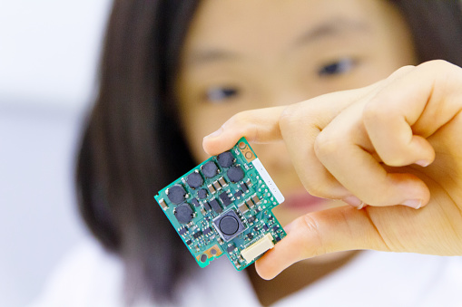 Japanese schoolgirl assembling circuit board, close-up