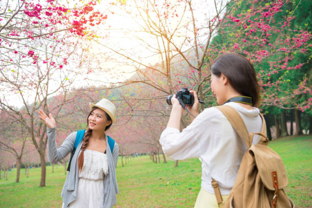 istock woman using camera helping friend taking picture 1015215158