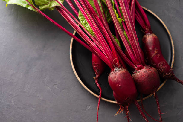 istock Beet, beetroot bunch on wooden plate on grey stone background. Copy space. . 1015217594
