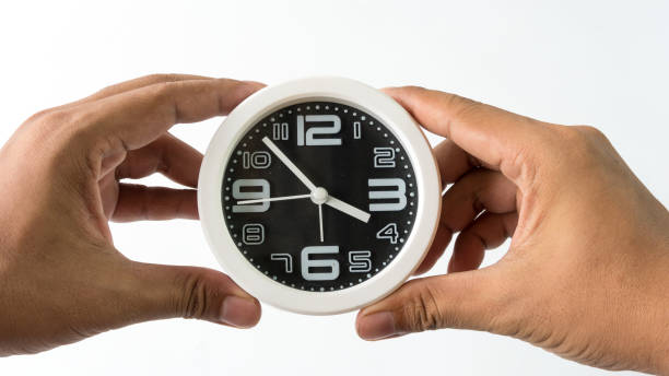 istock the clock background on gray color wall with hand holder 1015230290