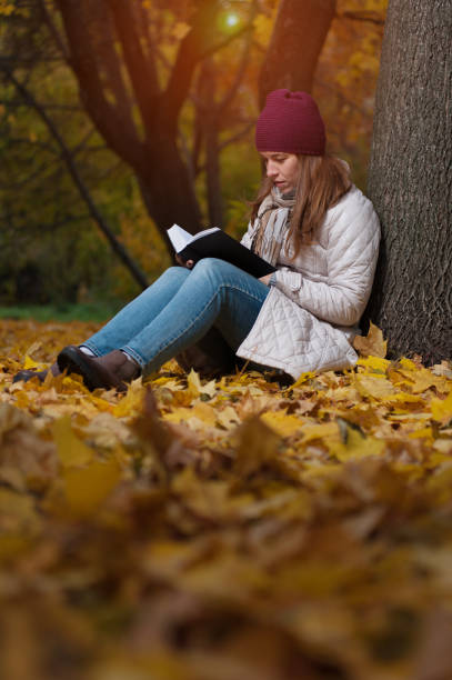 istock Thoughtful young female student sitting in the fall park 1015237680