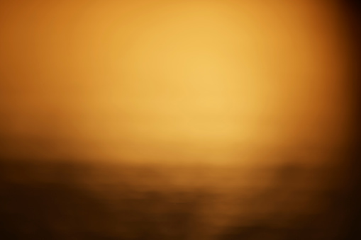 horizontal shot of defocused gold background in sunset time.