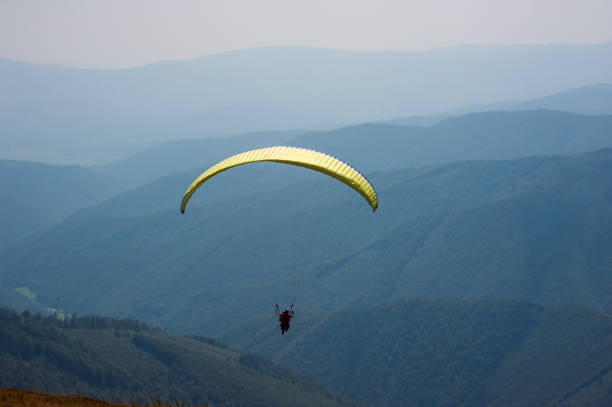 istock Paraglider flies over a mountain valley on a sunny summer day. 1015240100