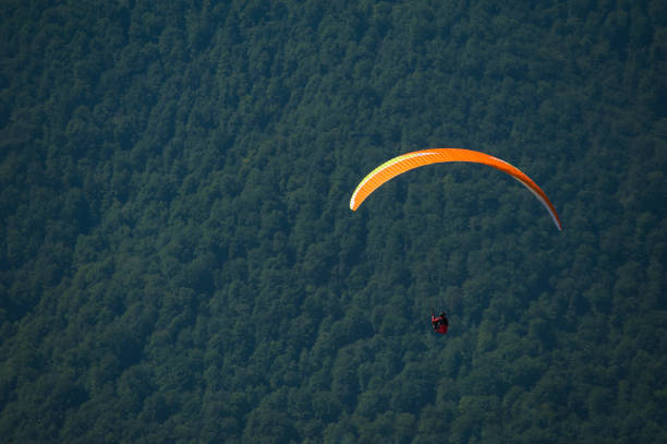 istock Paraglider flies over a mountain valley on a sunny summer day. 1015240302