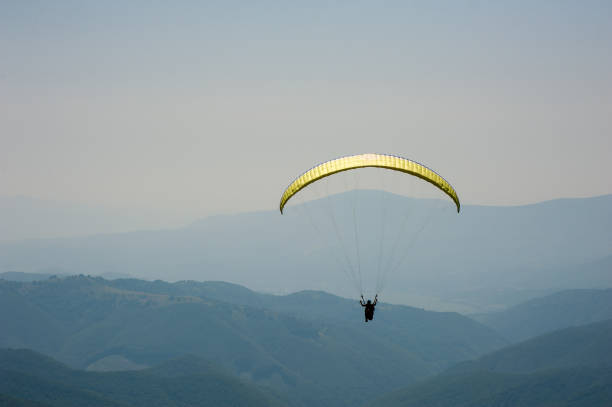 istock Paraglider flies over a mountain valley on a sunny summer day. 1015240318