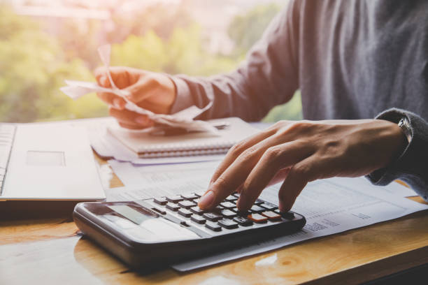 istock Young man using calculator and calculate bills in home office. 1015240686