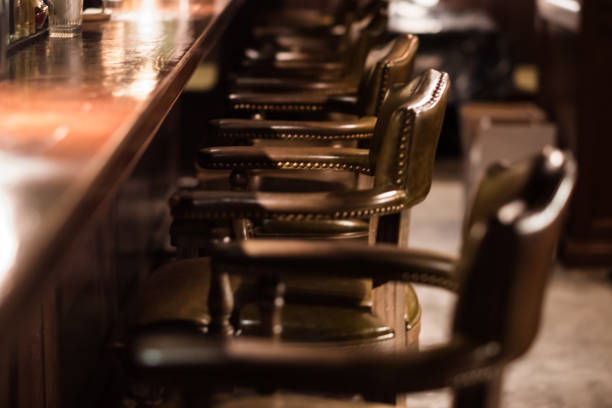 Bar Interior Design In Classic Vintage Style. Oak Wooden Bar Counter, Comfortable Chairs With Leather Upholstery And Cooper Rivets. Luxury Interior. Great Place For Relax After Work. Bar, Interior, Design, Classic, Luxury saloon photos stock pictures, royalty-free photos & images