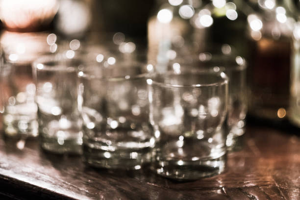 Drinking glasses in a row, upside down, drying after being washed, close-up. Food and drinks establishment.