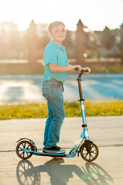 istock Cheerful Boy Riding Kick Scooter on City 1015255670